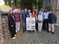 Gruppenfoto vor dem Impulsecenter mit Plakat